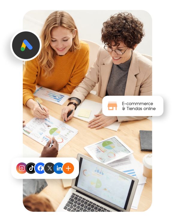Dos chicas analizando datos en una mesa con consultor de marketing digital
