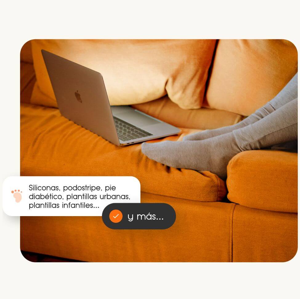 Persona en sofá naranja con portátil revisando el diseño página web