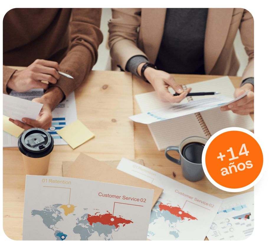 Dos personas en mesa con papeles analizando datos para consultora de marketing digital