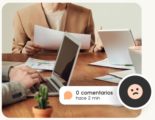 Personas en mesa con ordenadores y papeles trabajando redes sociales agencia